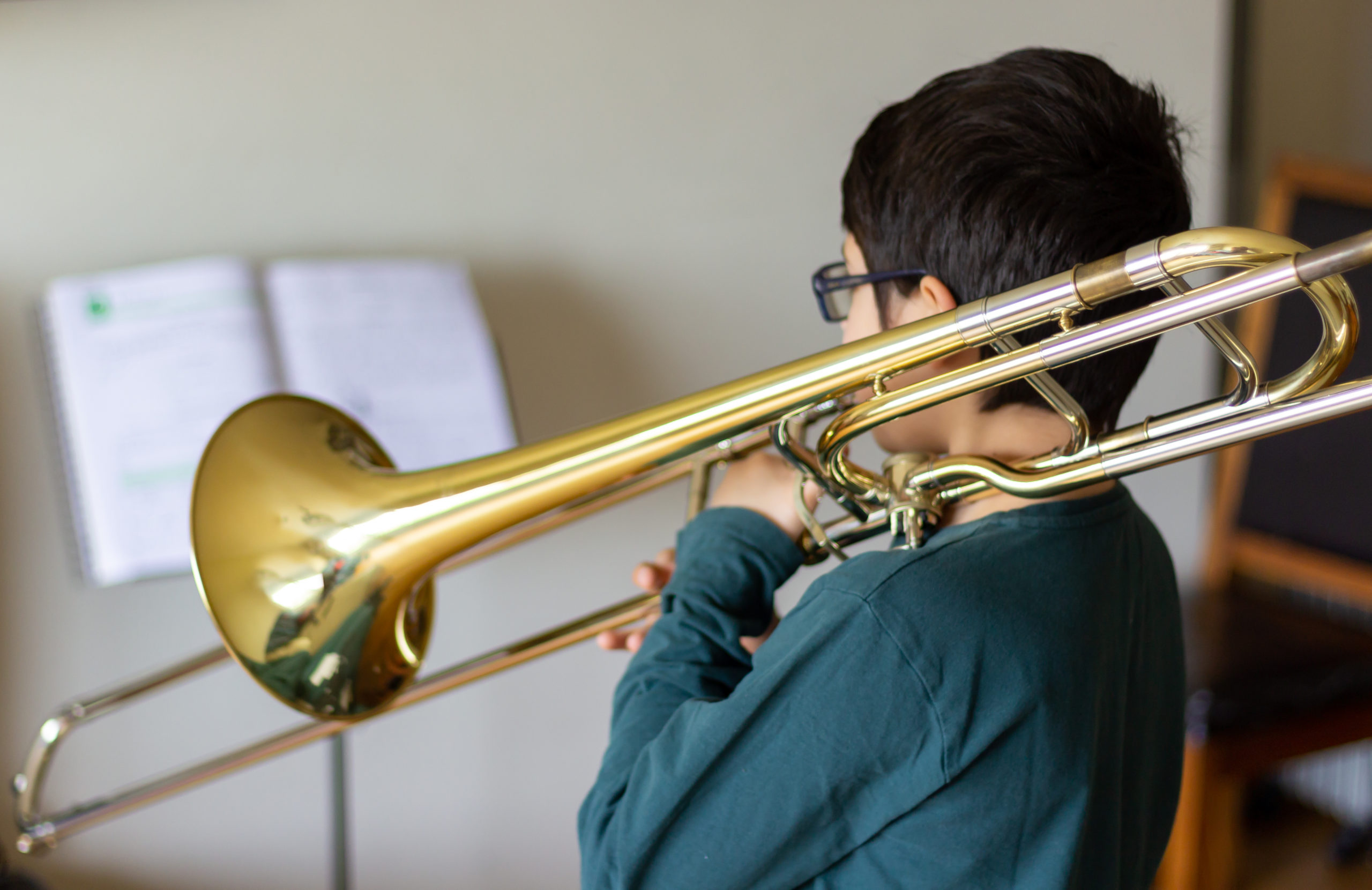 Menino a tocar trombone em casa.