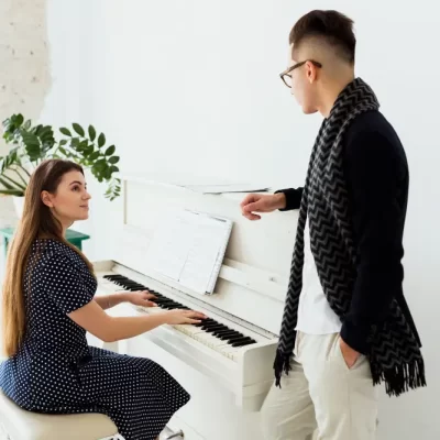 hombre-joven-que-mira-mujer-hermosa-que-toca-piano (1)