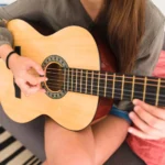 close-up-teenage-girl-s-hand-playing-guitar-scaled-_1_ Clases de guitarra española